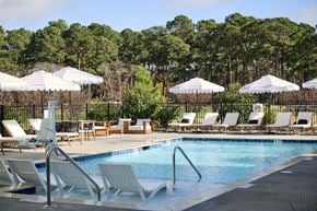 Calabash apartment for rent - Calabash, NC Pet-Friendly Apartments | The View at Crow Creek | Resort-Style Pool with Sundeck, Lounge Chairs, and Umbrellas.
