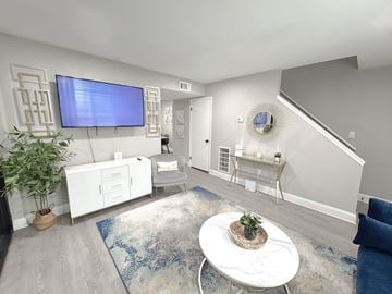 Spartanburg townhouse for rent - A living room with a white sofa and a television mounted on the wall.
