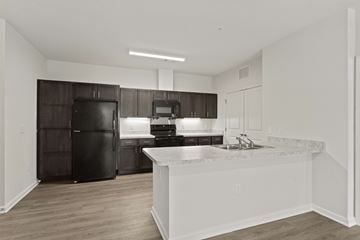 Greer apartment for rent - A kitchen with a black refrigerator and white countertops.