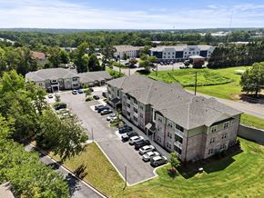 Greer apartment for rent - A large building with a parking lot in front of it.