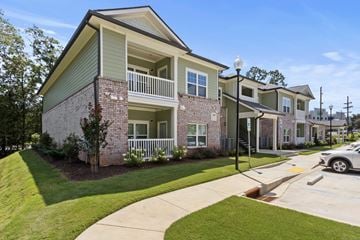 Greer apartment for rent - A two-story apartment building with a green roof and white balcony railings.
