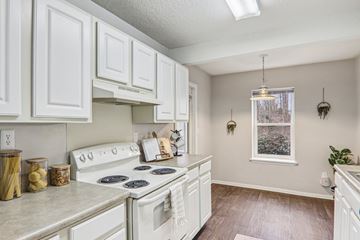 Greenville apartment for rent - A kitchen with white cabinets and a white stove top oven.