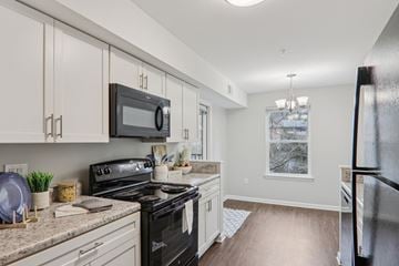 Greenville apartment for rent - A kitchen with a black stove top oven and white cabinets.
