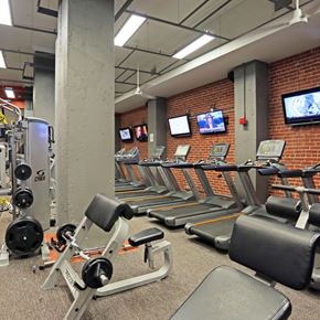 Tulsa apartment for rent - A gym with treadmills, weight machines, and televisions on the wall.