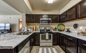Hewitt apartment for rent - A modern kitchen with dark wood cabinets and stainless steel appliances.