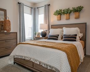 Oklahoma City townhouse for rent - A bedroom with a large bed and a wooden dresser.