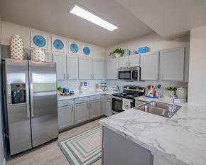 Oklahoma City townhouse for rent - A kitchen with a refrigerator, microwave, oven, and sink.
