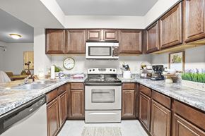 Owasso apartment for rent - A kitchen with wooden cabinets and a granite countertop.