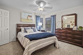Owasso apartment for rent - A bedroom with a bed, dresser, and mirror.
