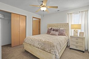 Wichita apartment for rent - A bedroom with a bed, dresser, and closet.
