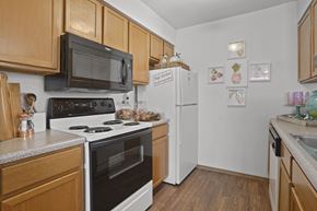 Wichita apartment for rent - A kitchen with wooden cabinets and a white refrigerator.