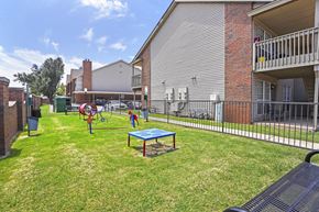 Oklahoma City apartment for rent - A playground with a blue table and a red swing set.