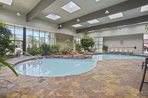 Wichita apartment for rent - A swimming pool in a room with stone flooring and ceiling.