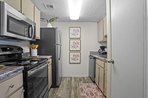 Oklahoma City apartment for rent - A kitchen with a black stove top oven and a black refrigerator.