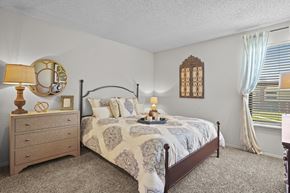 Wichita apartment for rent - A bedroom with a bed, nightstand, and window.