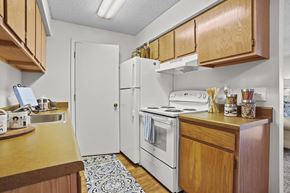Wichita apartment for rent - A kitchen with wooden cabinets and a white refrigerator.