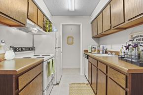 Wichita apartment for rent - A kitchen with wooden cabinets and a sign that says "Fresh Bar Pies Served Daily".