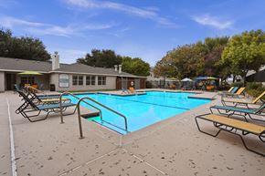 El Paso apartment for rent - A pool surrounded by chairs and trees.