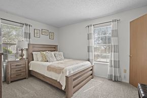 Oklahoma City apartment for rent - A bedroom with a bed, nightstand, and window.