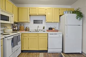 El Paso apartment for rent - A kitchen with yellow cabinets and white appliances.
