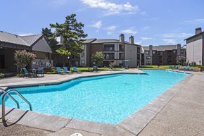 Oklahoma City apartment for rent - A swimming pool in a residential area with a sunny sky.