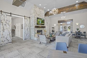 Yukon apartment for rent - A living room with a stone fireplace and a television mounted above it.