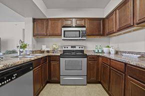 Yukon apartment for rent - A kitchen with a black dishwasher and a silver oven.