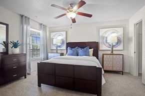Yukon apartment for rent - A bedroom with a large bed and a ceiling fan.