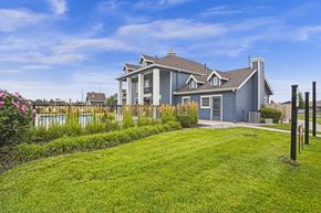 Wichita apartment for rent - A house with a well-maintained lawn and a pool in the background.