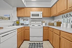 Wichita apartment for rent - A kitchen with wooden cabinets and a white dishwasher.