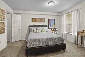 Wichita apartment for rent - A bedroom with a large bed and a painting on the wall.