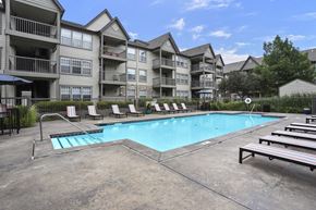 Wichita apartment for rent - A swimming pool in front of apartment buildings.