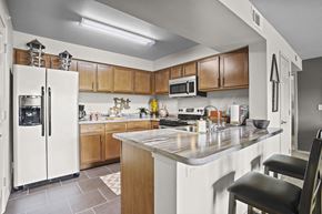Wichita apartment for rent - A kitchen with a white refrigerator and wooden cabinets.