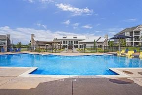 Wichita townhouse for rent - A large outdoor swimming pool with a building in the background.