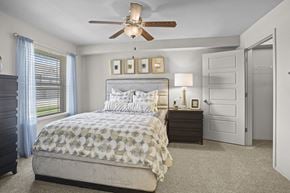 Wichita townhouse for rent - A bedroom with a large bed and a ceiling fan.