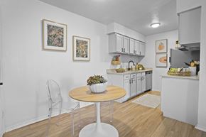 Stillwater apartment for rent - A kitchen with a table and chairs in the foreground and a counter with fruit on it in the background.