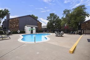 Stillwater apartment for rent - A small pool in a concrete area with a yellow barrier.