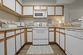 Amarillo apartment for rent - A white oven is in the middle of a kitchen with wooden cabinets.
