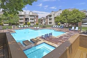 Amarillo apartment for rent - A large swimming pool with lounge chairs and apartment buildings in the background.
