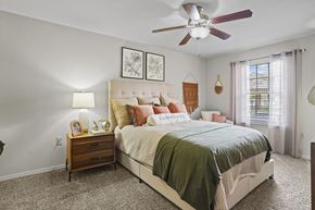 Amarillo apartment for rent - A bedroom with a large bed and a ceiling fan.