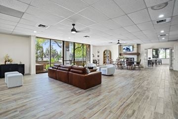 El Paso apartment for rent - A spacious living room with a brown leather couch and a white ottoman.