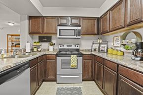 Lubbock apartment for rent - A kitchen with a stove top oven and a microwave above it.