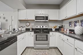 Lubbock apartment for rent - A modern kitchen with white cabinets and stainless steel appliances.