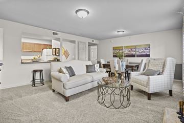 Edmond apartment for rent - A living room with a white couch, a coffee table, and a painting on the wall.