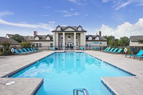 Edmond apartment for rent - A large swimming pool in front of a house.