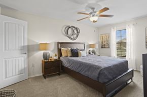 Maize apartment for rent - A bedroom with a bed, nightstand, and a ceiling fan.