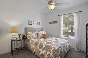 El Paso apartment for rent - A bedroom with a patterned bedspread and a ceiling fan.