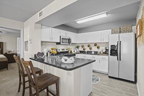 Maize apartment for rent - A kitchen with a black counter top and white cabinets.