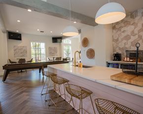 Little Rock apartment for rent - A kitchen with a white counter and a bar area with stools.