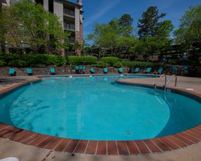 Little Rock apartment for rent - A round swimming pool with blue water and a brick border.